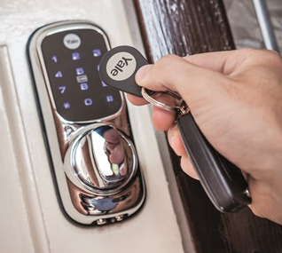a hand places a round tag next to a lock which is lighting up